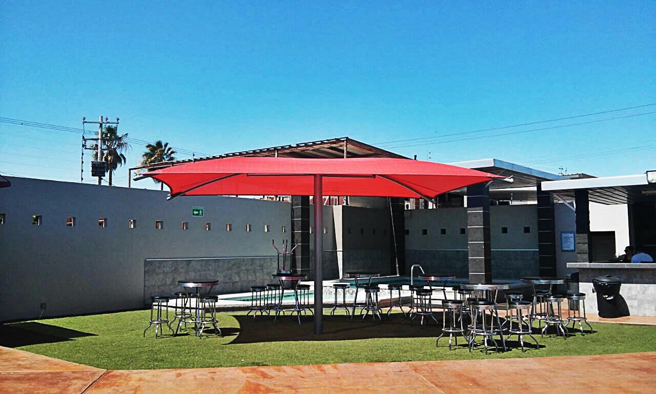 Big Brella roja instalada sobre área recreativa infantil